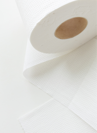 Close-up of a white toilet paper roll with textured sheets partially unrolled