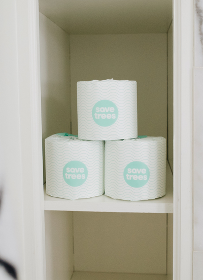 Three rolls of Save Trees bamboo toilet paper stacked on shelf